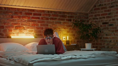 hombre trabajando en la computadora portátil en la cama por la noche