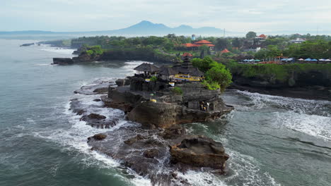 drone circles tanah lot temple on misty bali morning in indonesia