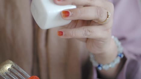woman seasoning a tomato salad