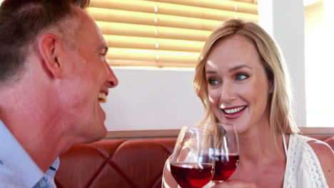 pareja feliz interactuando mientras tienen una copa de vino 4k