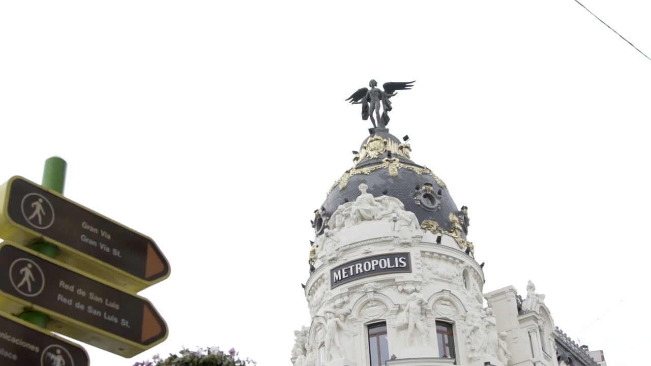 Slow motion: Madrid Metropolis building and street signs
