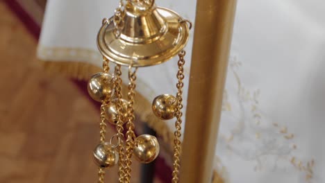 ornate censer with decorative chains and bells, detailed close-up