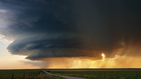 dramatic supercell thunderstorm at sunset over a rural landscape