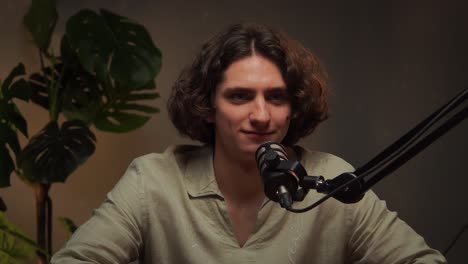 young man recording a podcast in a studio