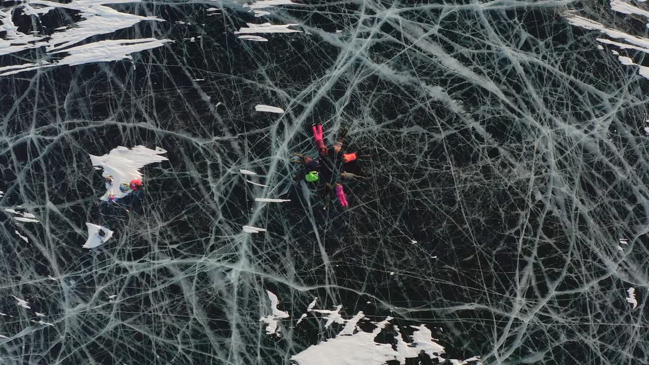 관광객들은 얼어붙은 베이칼 호수의 얼음 위에 누워서 동기화된 움직임을 수행합니다.