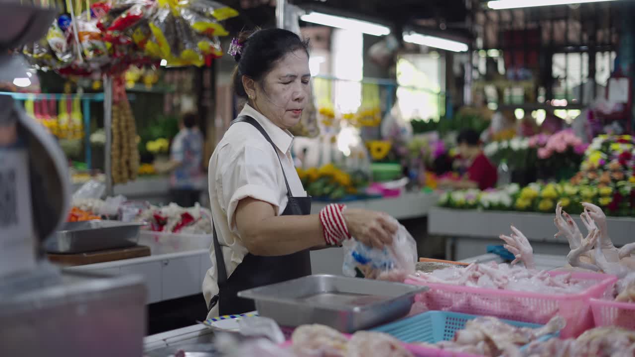 Woman selling fresh chickens in a bustling Asian market