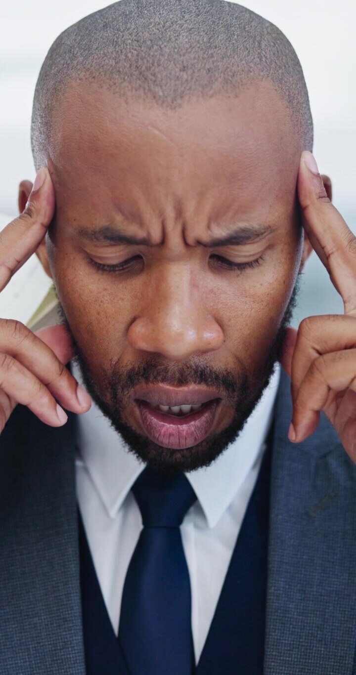 Stressed Businessman Rubbing Temples in Office