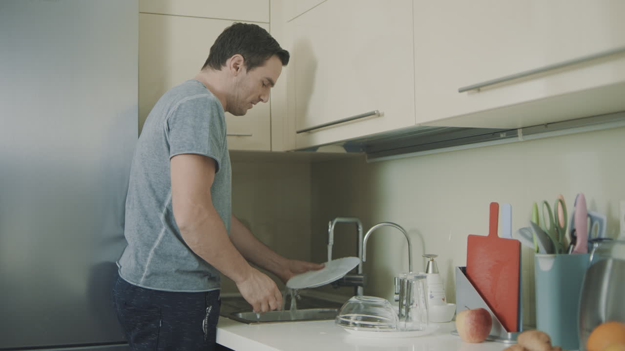 Marido alegre haciendo las tareas del hogar en cámara lenta.