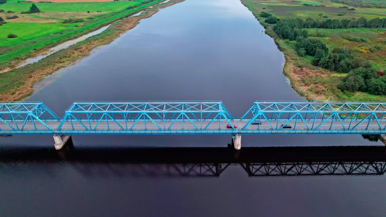 Stunning aerial view of a blue bridge crossing a river in Latvia
