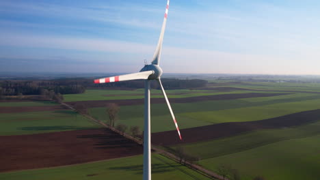 Una-Gran-Turbina-Eólica,-Aspas-Giratorias-De-Molino-De-Viento-Industrial-En-Polonia-Al-Atardecer---Primer-Plano-Aéreo