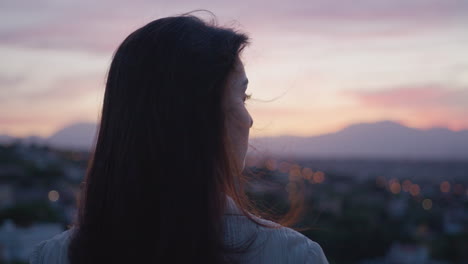 medium close up of the side profile of a young white woman during the sunset or sunrise with mountain landscape