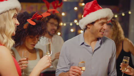 multi-cultural group of friends celebrating making toast enjoying christmas party night in bar