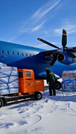 aircraft delivers cargo in snowy landscape of antarctica during daytime
