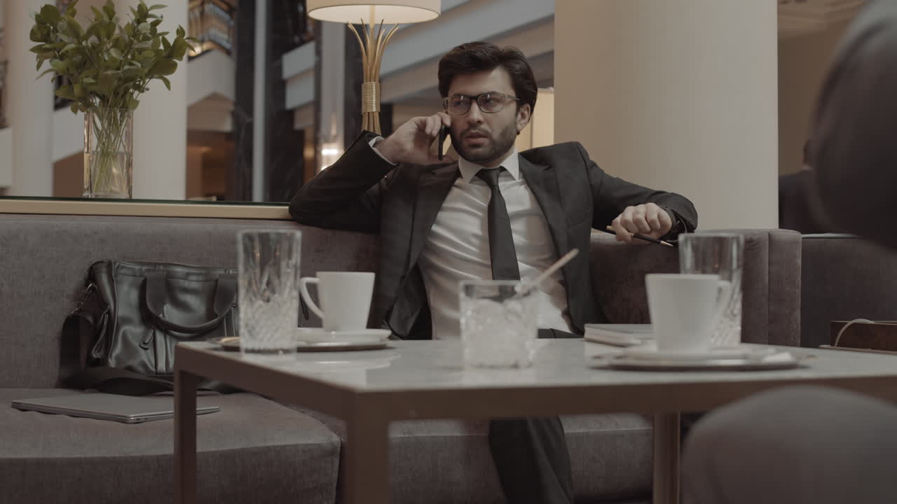 Businessman Talking on Phone in Lobby