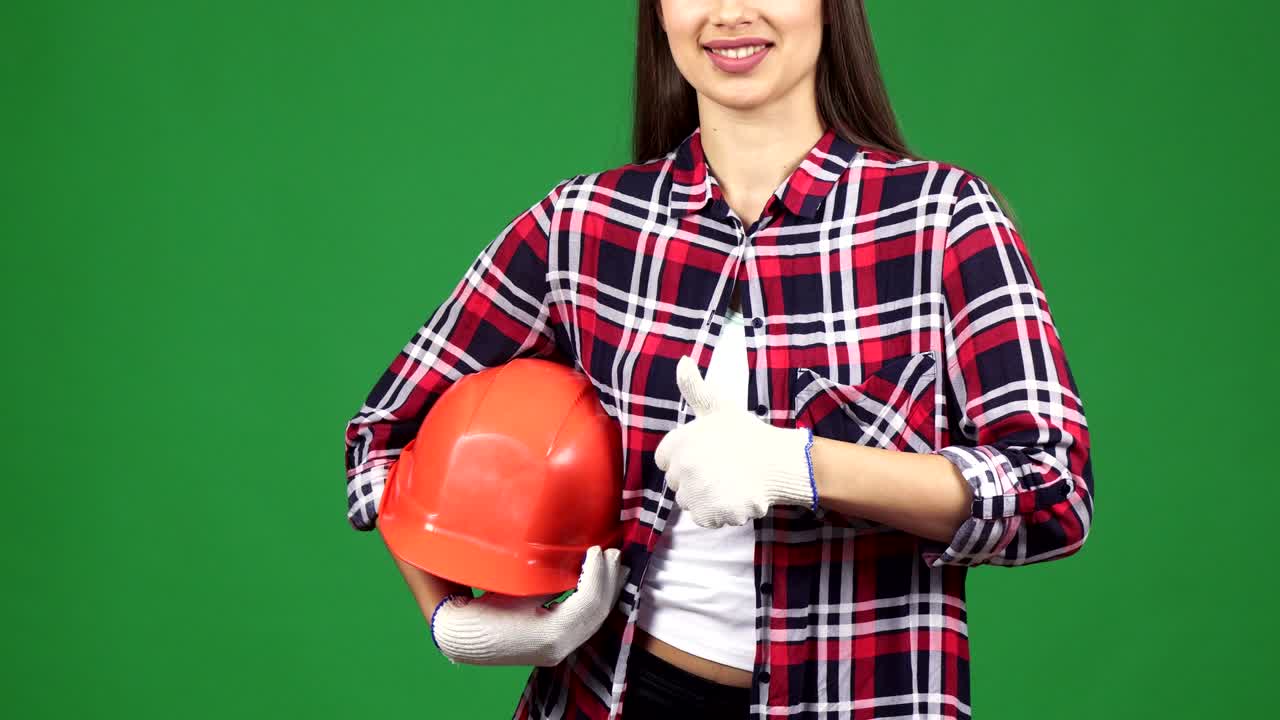 Cropped shot of a smiling female engineer showing thimbs up holding hardhat