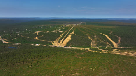 Drone-circling-the-slopes-of-the-Saariselka-ski-center,-summer-day-in-Lapland