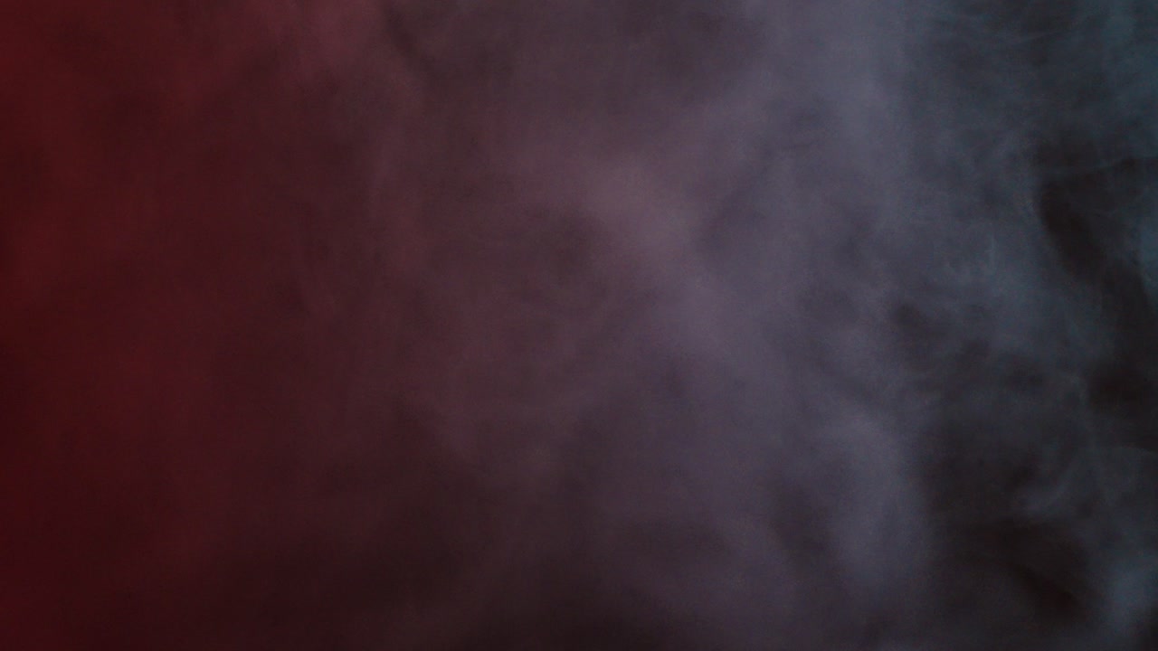 Dense smoke and mist drift across a dark background illuminated by subtle red and gray tones, creating a mysterious, cinematic, and atmospheric visual effect