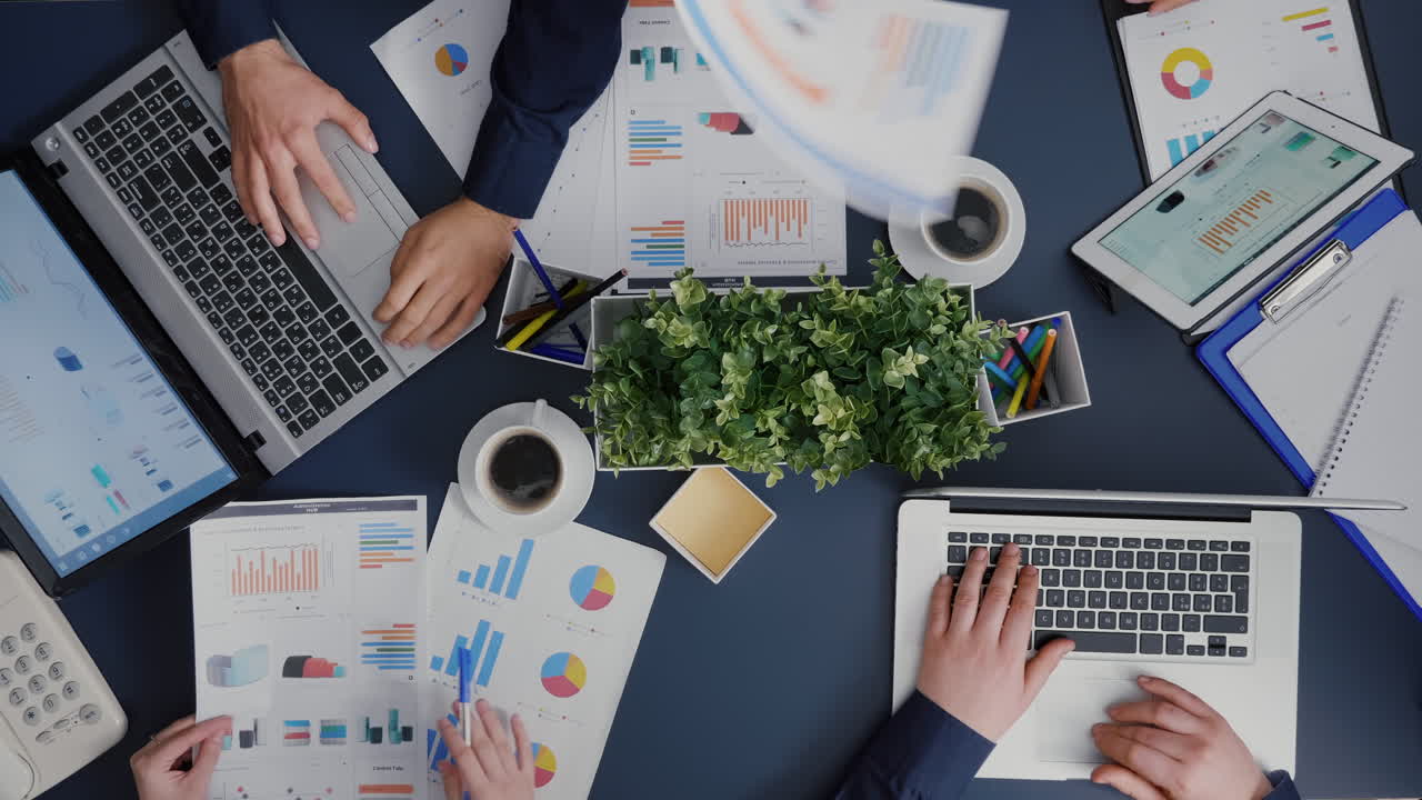 Top view of business teamwork analyzing company accounting paperwork