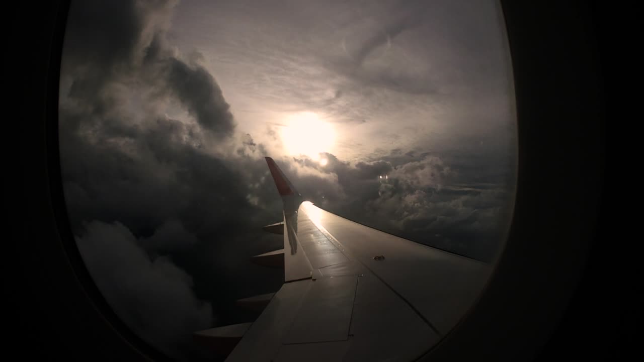 Zonsondergang en prachtige wolken vanuit het raam van de linkervleugel van het vliegtuig brengen reisherinneringen terug