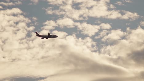 slow motion tracking shot of a 747 plane flying at sunset
