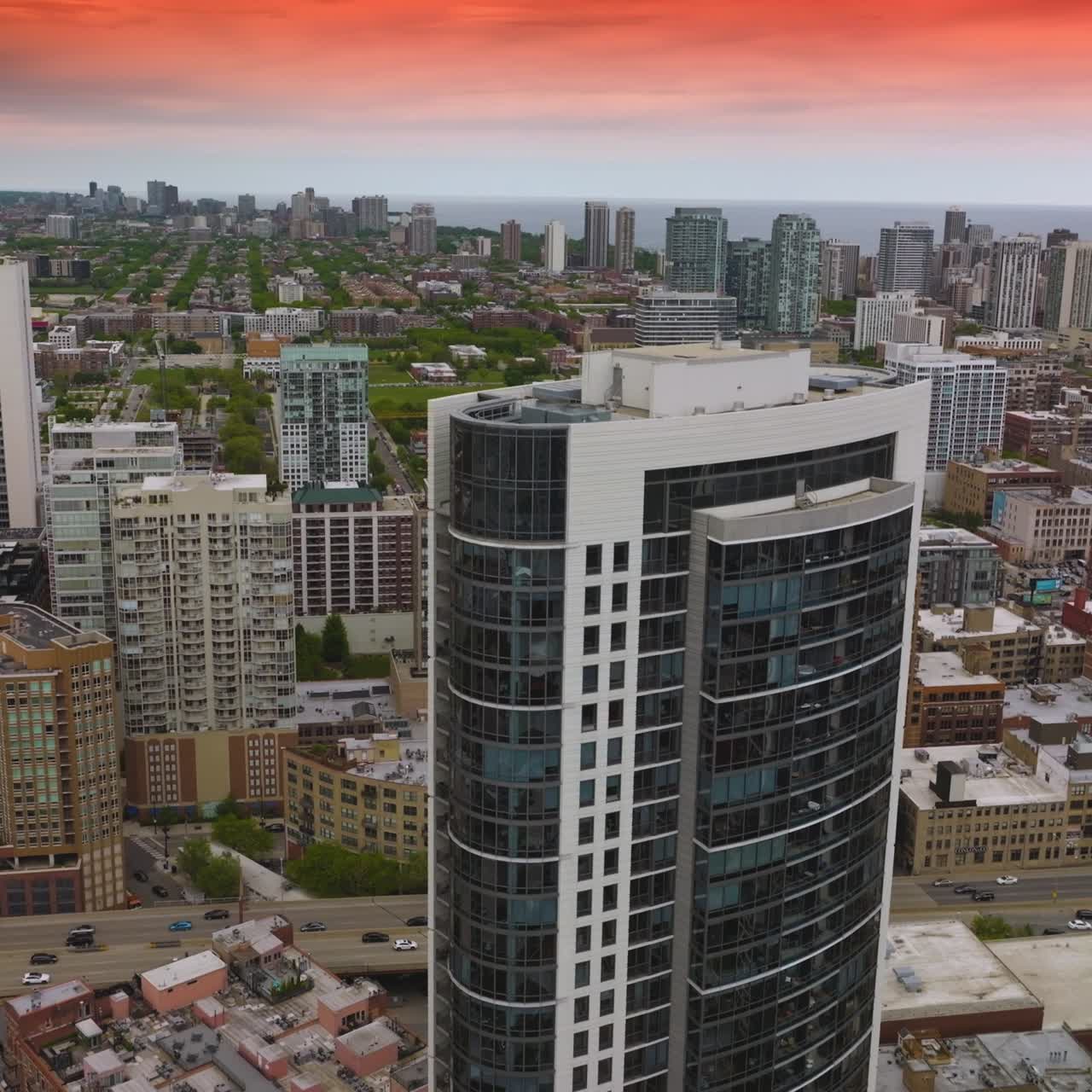 Scenery of beautiful Chicago with diverse buildings. Cars crossing bridges over the river. Pink sunset at background
