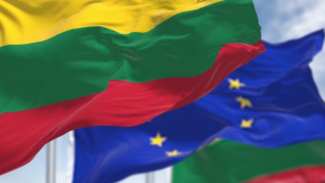 detalle de la bandera nacional de lituania ondeando en el viento con la bandera borrosa de la unión europea en el fondo