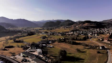 aerial flight over a village in the mountains of the julian alps. bright sunny day in slovenia with a small village nestled in the mountains