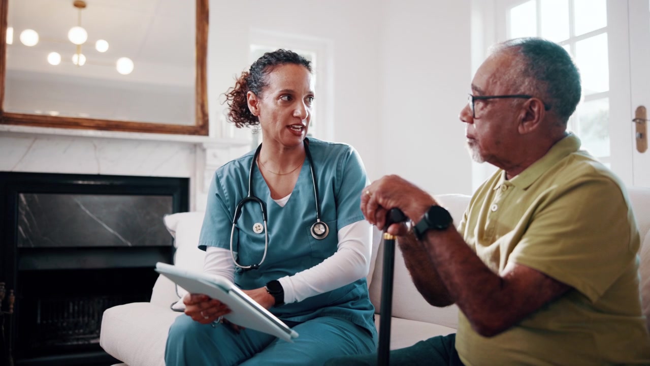 Female Nurse Consulting Senior Man at Home