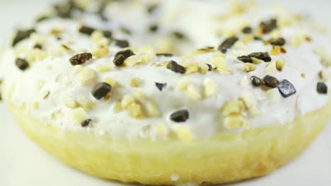 cream and peanut coated pies doughnut rotating on the table