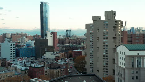 Rising-tilt-down-footage-of-various-multistorey-buildings-in-city.---Fly-over-rooftop-water-tank.-Manhattan,-New-York-City,-USA