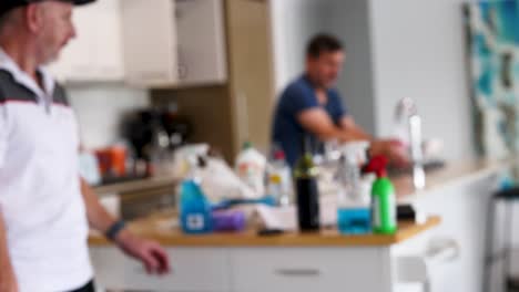 a person washes hands in a well-lit kitchen, emphasizing hygiene. the environment is bright and organized, with visible cleaning supplies