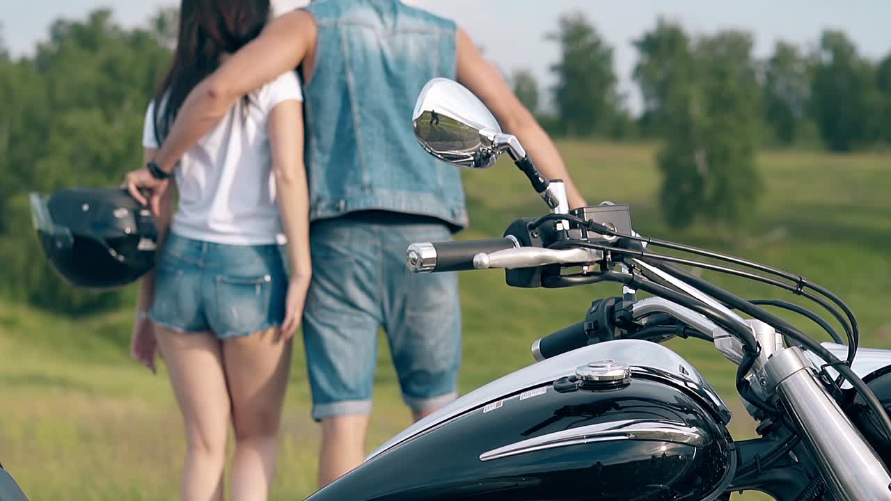 뒷면 보기 청바지 옷을 입은 남자가 젊은 여자를 포옹합니다.