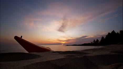 Zeitraffer-Sonnenuntergang-Mit-Kajak-Am-Strand-Und-Meer