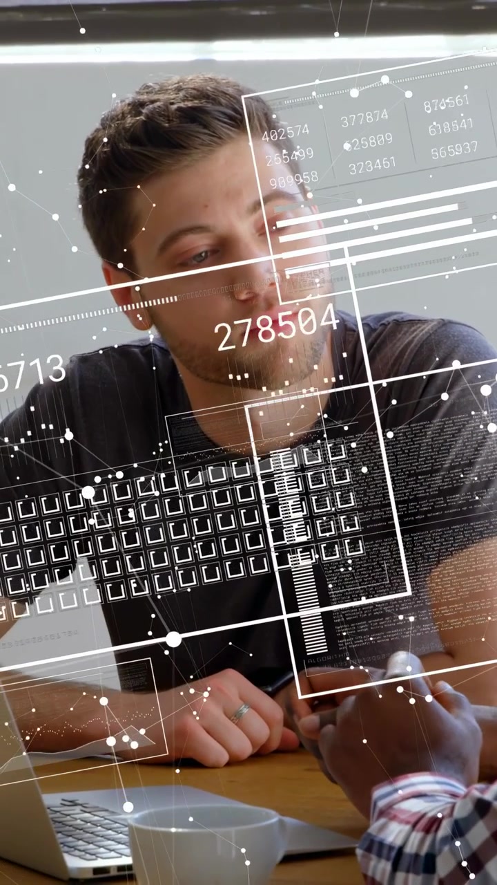 Vídeo vertical: Homem ouvindo enquanto um colega usa o telefone, com um HUD atualizando o laptop para revisão tecnológica.