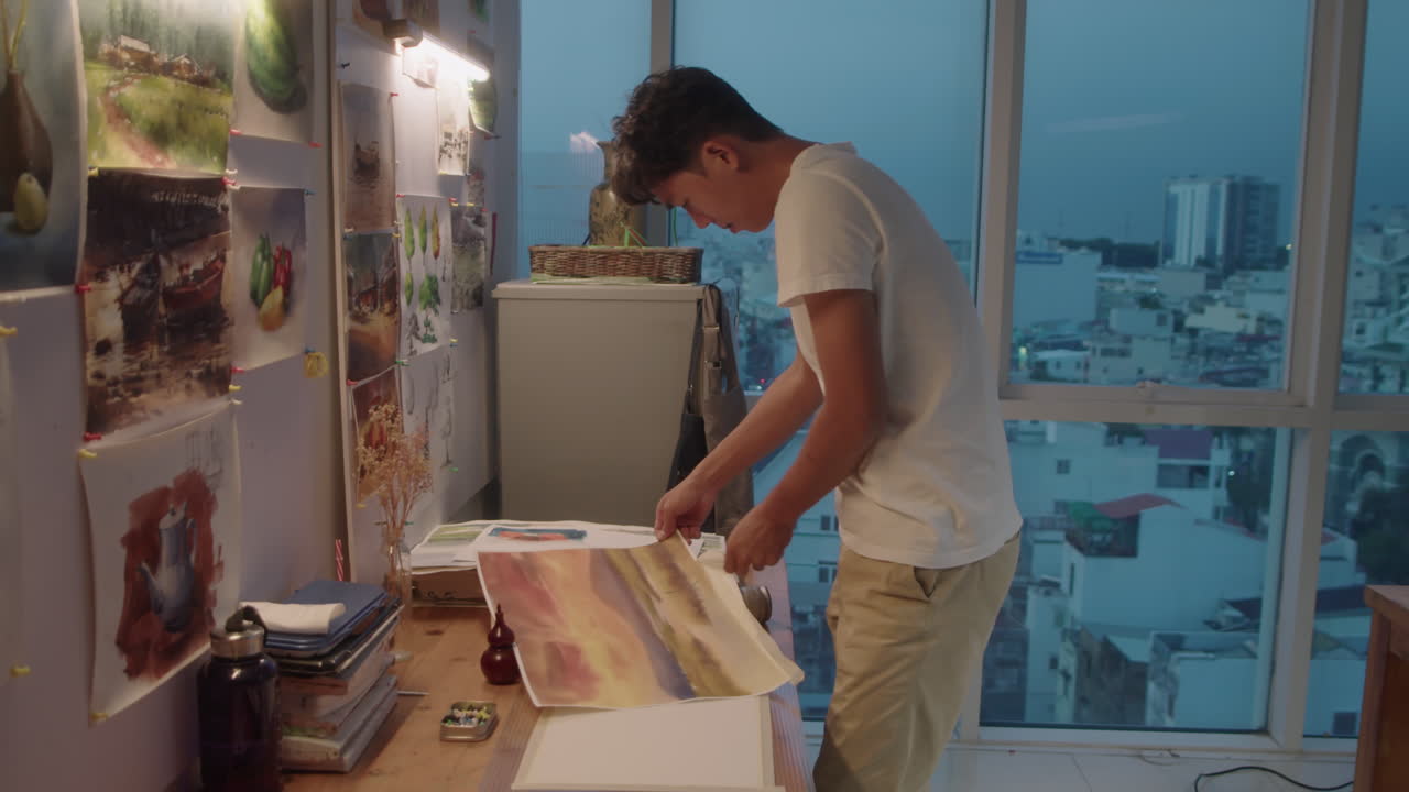 Artista asiatico che rimuove il nastro adesivo da un dipinto