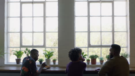 group of black friends drinking coffee together in cafe talking having conversation enjoying socializing on lunch break in restaurant shop