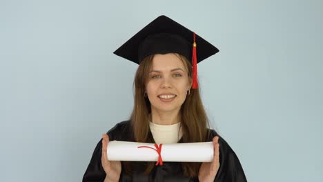 young female student in a black gown and a master's hat holds in her hands in a horizontal position a diploma of higher education. white background