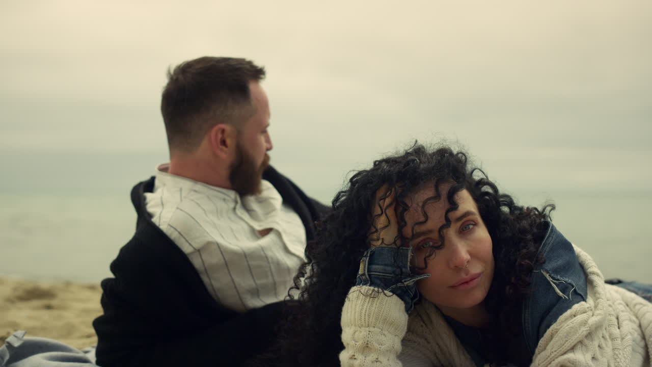 una pareja joven relajándose en la playa. gente tranquila acostada en un paisaje marino con un fondo natural.