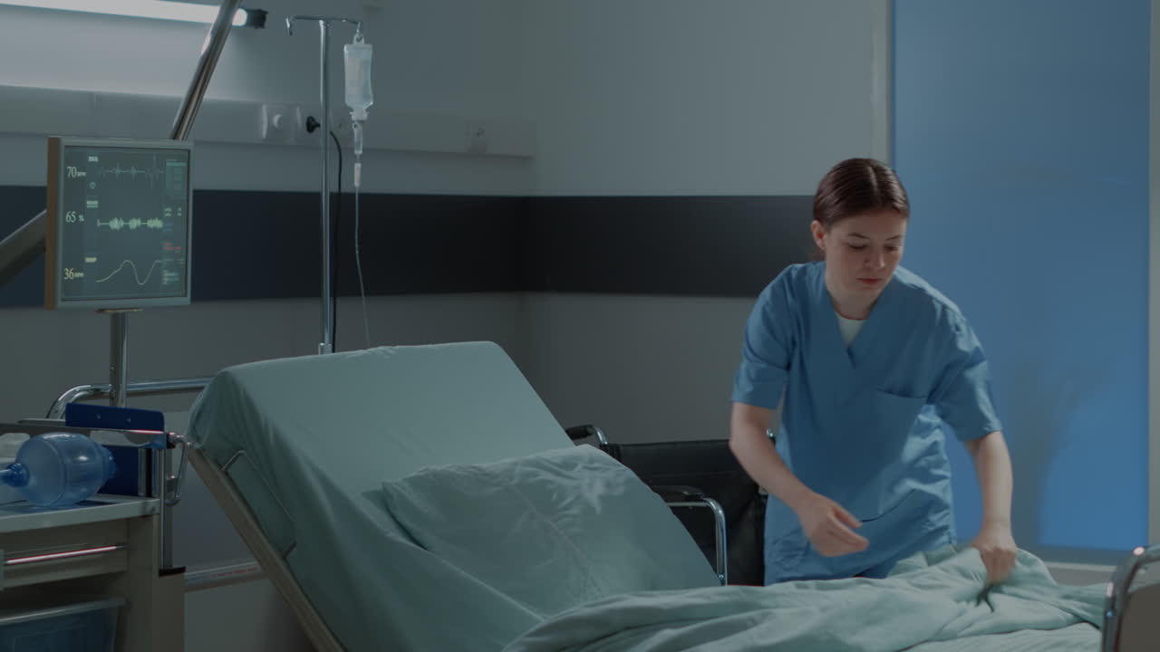 Caucasian nurse making hospital ward bed for use