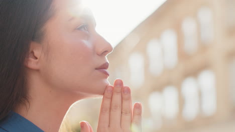retrato de una mujer orando con los ojos cerrados a dios pidiendo bendición ayuda perdón al aire libre