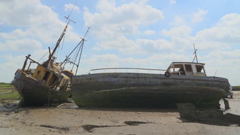 Shipwrecks-under-bright-cloudy-sky-on-summer-day,-with-cloud-shadows-moving