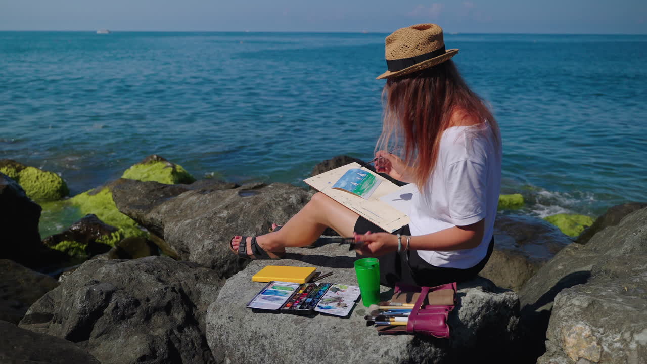 해변 에 바다 풍경 을 그리는 여자