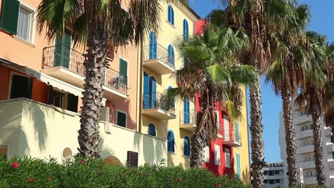 colorful seaside town in italy with palm trees swaying in the wind