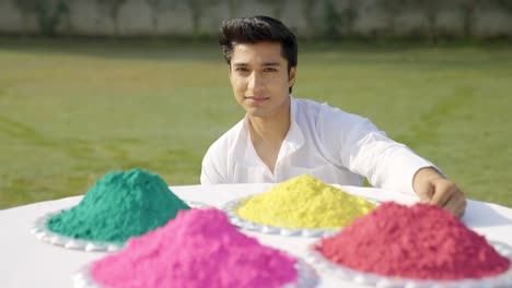 indian man with holi colors looking at the camera