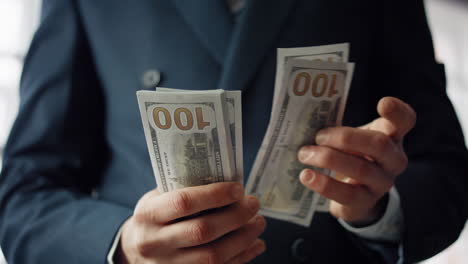 closeup hands counting cash american dollars indoors. man having pack money.