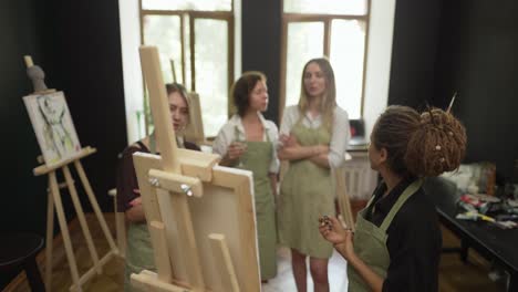 female students at art workout leading by mentor, listen for instructions