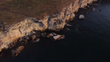 drone top down aerial view of waves splash against rocky seashore, background