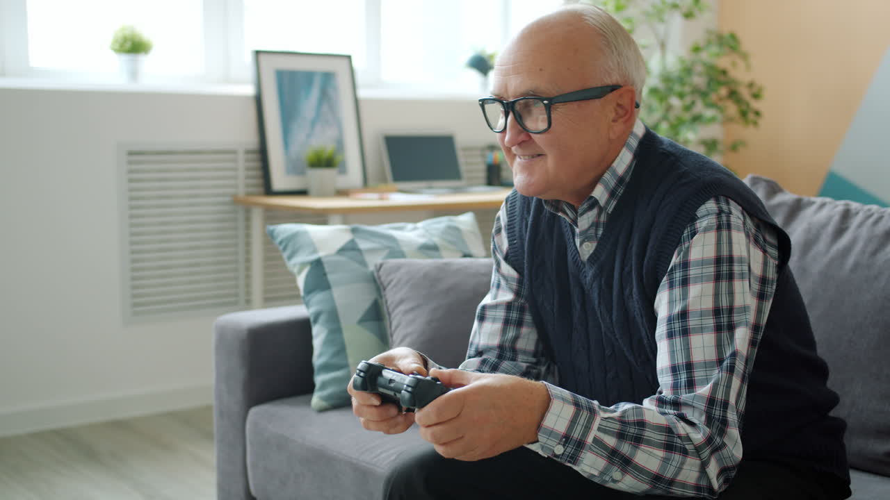 Senior man playing video games at home