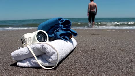 camera with beach lying and glasses on the sandy beach 1