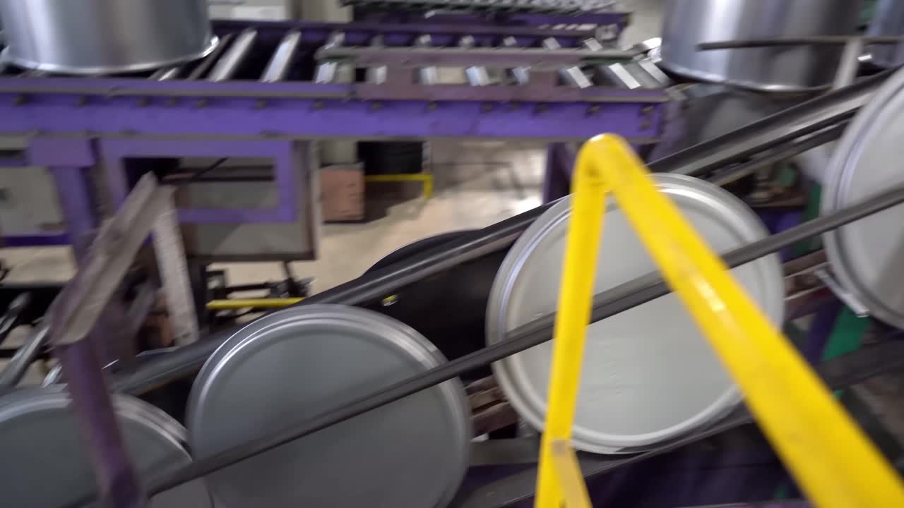 Steel drum lids travel steadily on a conveyor for further processing